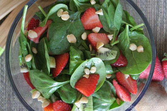 spinach strawberries and nuts in a bowl