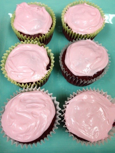 red velvet cupcakes with pink frosting on blue plate